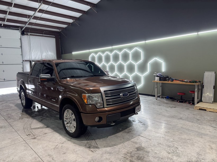 Copper brown Ford F-150 Platinum with fresh window tint under the hexagon LED lights