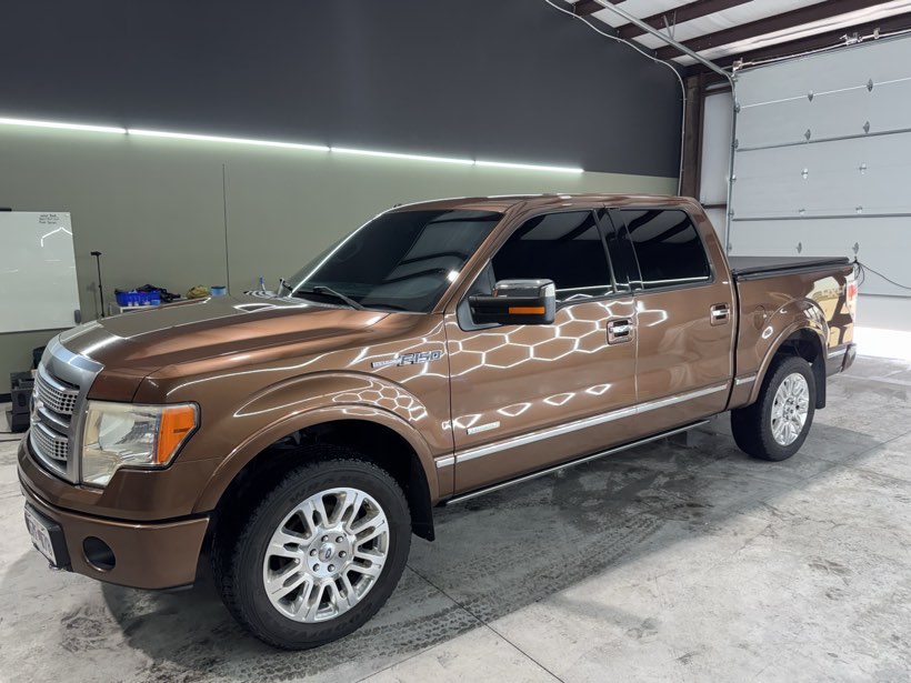 Side profile of a copper brown Ford F-150 Platinum with evenly matched window tint